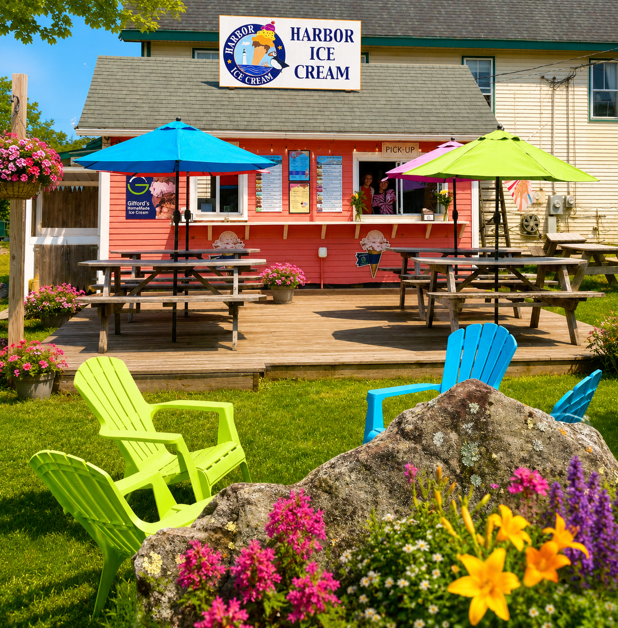 The coral-red Harbor Ice Cream shop on the Hill in New Harbor, Maine with picnic tables and an OPEN flag